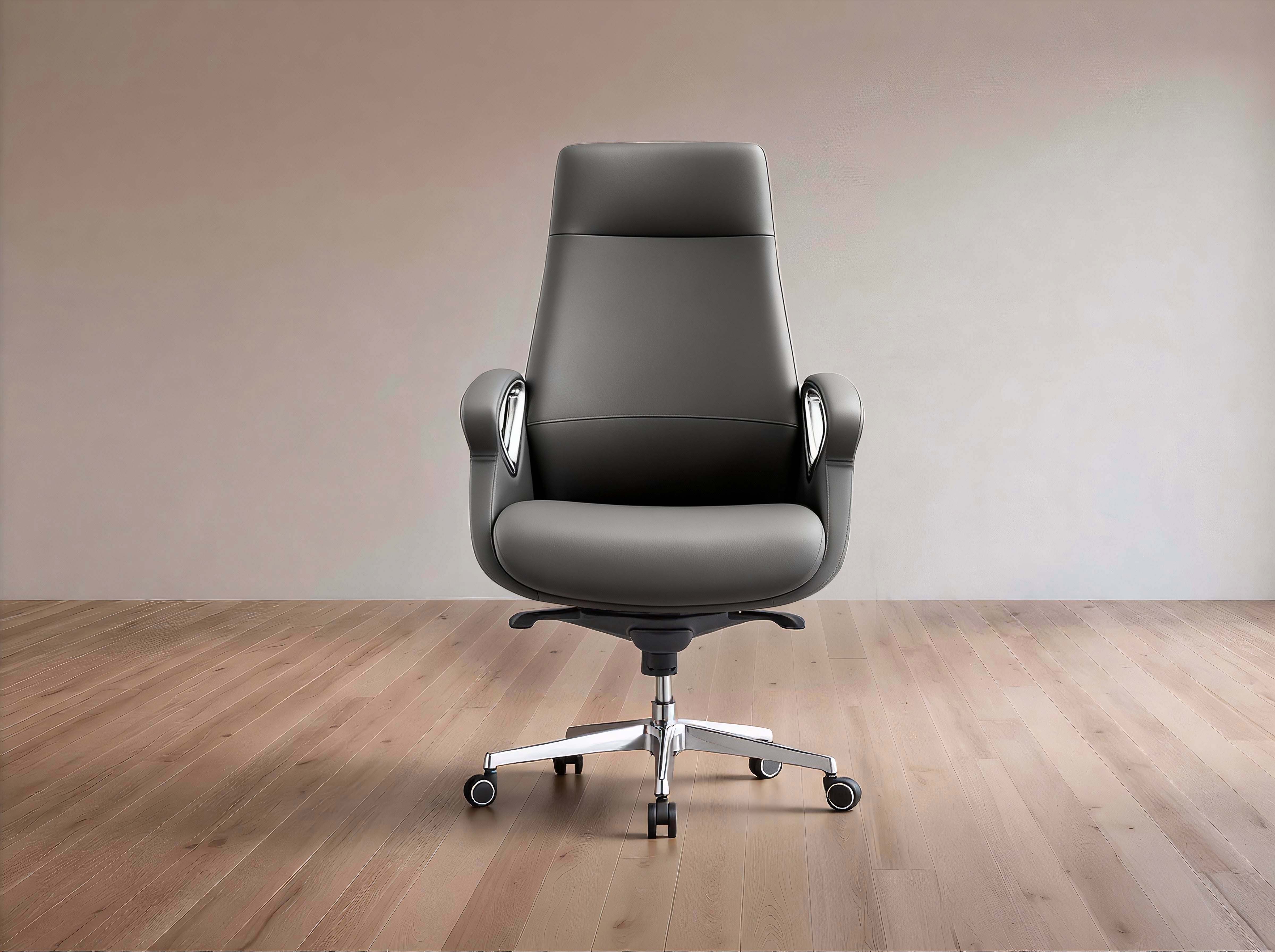 A modern gray leather office chair with a high back, chrome armrests, and a five-star silver metal base with casters, set against a minimalist beige wall and light wood floor.