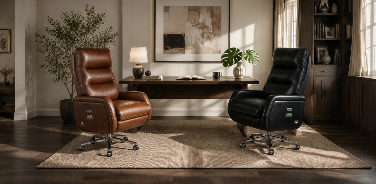 Two premium office chairs in a styled home office setting: a brown leather recliner on the left and a black leather office chair on the right, positioned on a beige rug around a wooden desk.