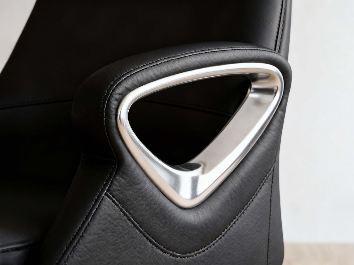 Close-up of a black leather office chair armrest featuring a prominent polished silver metallic triangular accent frame.