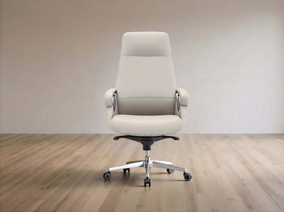 A modern off-white leather office chair with a high back, armrests, and a chrome five-star base with casters, set against a minimalist beige wall and light wood floor.
